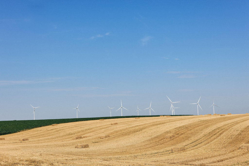 Paysage vendéen près de Luçon avec champ moissonné, bottes de paille et éoliennes
