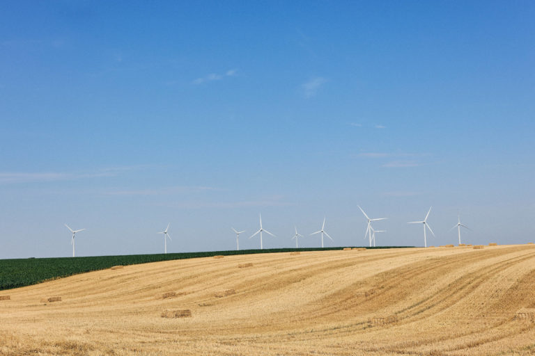 Paysage vendéen près de Luçon avec champ moissonné, bottes de paille et éoliennes
